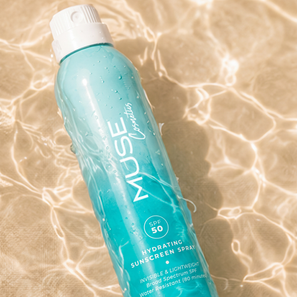 Applying MUSE SPF 50 body spray at the beach